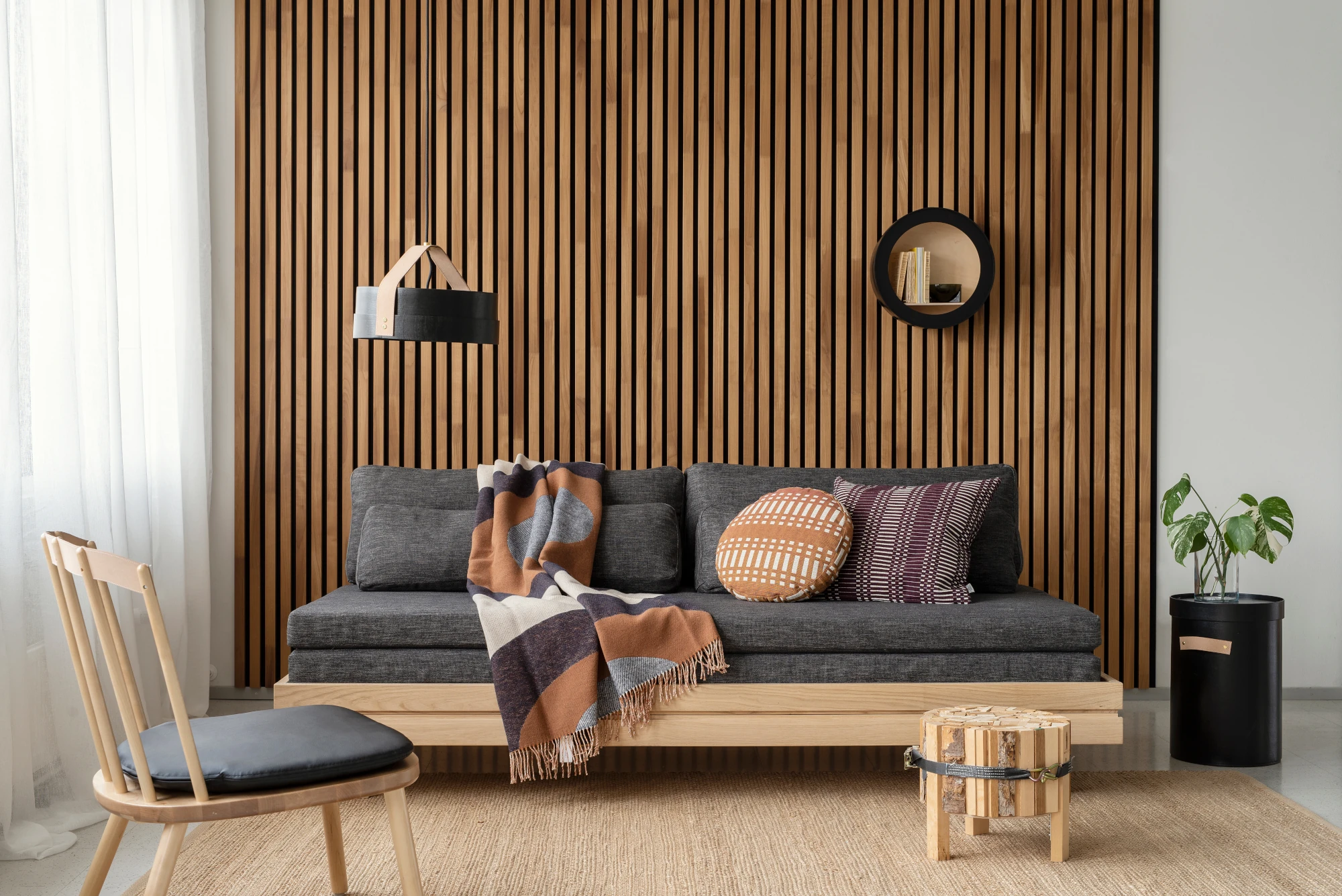 Wohnzimmer mit Sofa vor Wandverkelidung Akustikpaneele