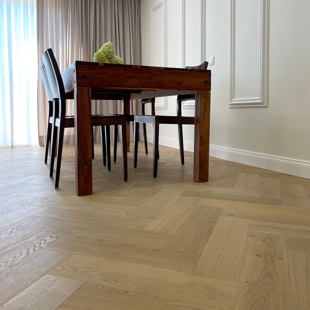 Stilvoll kombiniert: Dekorative ORAC Stuckelemente und helles Fischgrätparkett 